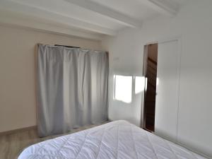 a white bedroom with a bed and a window at Charmante maison à Groix, 2 chambres - FR-1-813-14 in Groix +4 photos