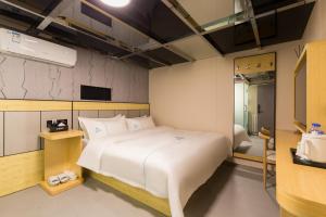 Llit o llits en una habitació de Dequan Hotel Chaoyang Park Branch Coffee fruits, snacks a gym and a laundry room are provided for free in the lobby