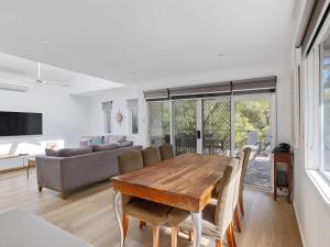 Una sala de estar con una mesa y sillas de madera. en Beachside Family Haven, en Inverloch