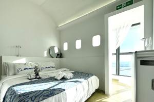a white bedroom with a bed and a large window at Dooga Ins-Boeing 777X Seaview in Johor Bahru