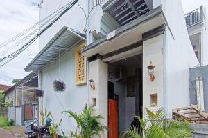 a white house with a red door at Widi Guest House near GWK Mitra RedDoorz in Jimbaran