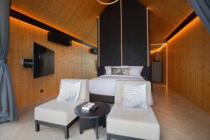 een slaapkamer met 2 bedden en 2 stoelen en een tafel bij The Pino Khao Kho in Phetchabun