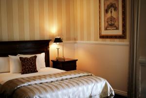 a bedroom with a bed and a lamp on a table at Redearth Boutique Hotel in Mount Isa