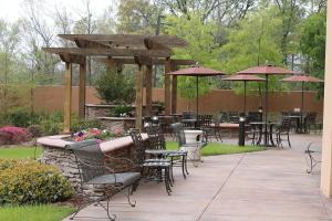 a patio with tables and chairs and umbrellas at Courtyard by Marriott Vicksburg in Vicksburg