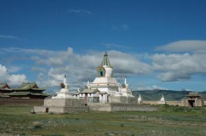 a large white temple in a field with a blue sky at UB Guesthouse & Tours - not for locals in Ulaanbaatar