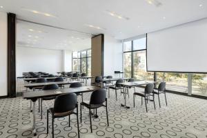 a conference room with tables and chairs and a large screen at Fairfield by Marriott Bogota Embajada in Bogotá