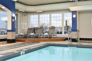 a pool with chairs and a swimming pool at Amenida Residences, Calgary in Calgary