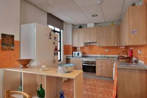 a kitchen with wooden cabinets and a white refrigerator at Casa Rural La Caja in Cogollos De La Vega