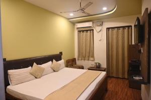 バラナシにあるHotel Gokul Grandの白いシーツが敷かれた大きなベッドのある寝室 +25枚の写真