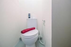 une serviette rouge posée sur les toilettes dans une salle de bain dans l'établissement Comfortable and Minimalist Studio at Bogorienze Apartment By Travelio, à Pamoyanan 9 autres photos