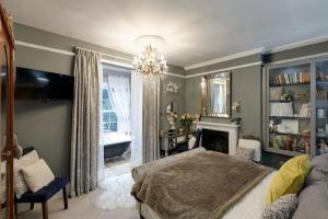 a bedroom with a bed and a fireplace and a chandelier at Grand Georgian Villa Sleeps up to18 Guests Dogs Welcome in Linton +105 photos