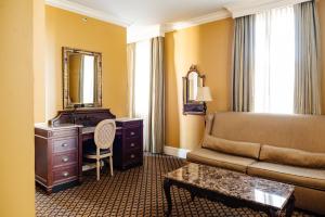 a living room with a couch and a dresser and a mirror at The Lafayette New Orleans by Kasa Living in New Orleans
