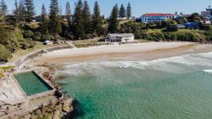 an aerial view of a beach with a house at The Palms Yamba - Overlooking Convent Beach in Yamba
