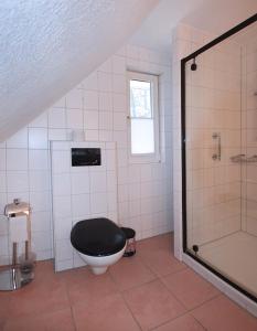 a bathroom with a black toilet and a shower at Am Darßwald Haus 2 1 in Prerow +15 photos