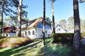 a white house in the woods with trees at Am Darßwald Haus 2 1 in Prerow