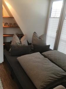 a bed with pillows on it in a room at City Stadthaus Auszeit Ankommen, genießen und leben in Balingen