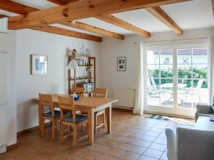 a dining room with a wooden table and chairs at Dat Müggenhus in Wieck in Wieck