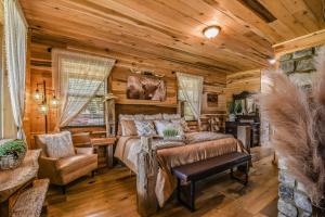 een slaapkamer in een blokhut met een bed en een stoel bij Just Like Paradise cabin in Sevierville