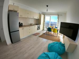 a kitchen with a refrigerator and a table with chairs at Panoramic Residence in Zărneşti