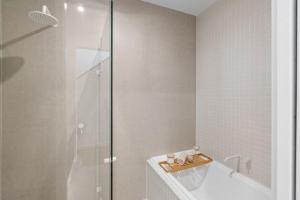 a bathroom with a shower and a toilet and a tub at Sunsets Aldinga Beach, 4 king rooms, rooftop, incredible views in Aldinga Beach +67 photos