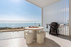 a room with a table and a view of the ocean at Sunsets Aldinga Beach, 4 king rooms, rooftop, incredible views in Aldinga Beach