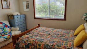 a bedroom with a bed and a dresser and a window at There's Room For All in Hawks Nest