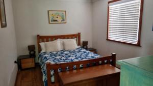 a bedroom with a bed with a blue and white comforter at There's Room For All in Hawks Nest