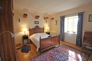 a bedroom with a bed and a window at La feuillardiere in Dournazac