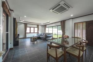 a living room with a glass table and a couch at V155 4BR Large Family Villa Chalong in Chalong 