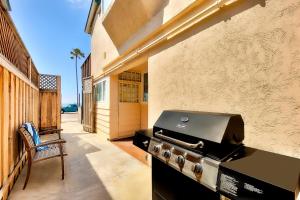 a outdoor patio with a grill and a table and chair at OB Pier 1 in San Diego