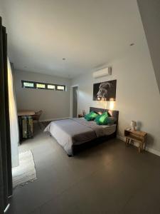 a bedroom with a bed with green pillows at Anam luxury 4 Bedroom House in Pereybere