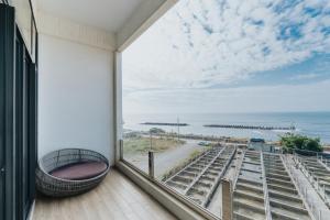 a balcony with a view of the ocean at 緩慢大鵬灣 in Donggang