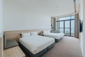 a hotel room with two beds and a tv at 緩慢大鵬灣 in Donggang