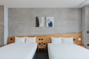 two beds sitting next to each other in a room at 緩慢大鵬灣 in Donggang