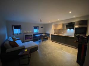 a living room with a couch and a kitchen at Haus Wolfsbach in Rennweg