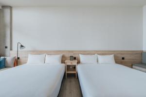 two beds sitting next to each other in a room at 緩慢大鵬灣 in Donggang