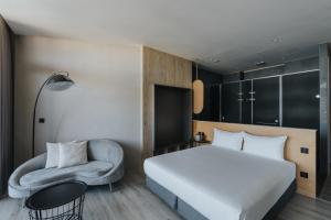 a hotel room with a bed and a chair at 緩慢大鵬灣 in Donggang