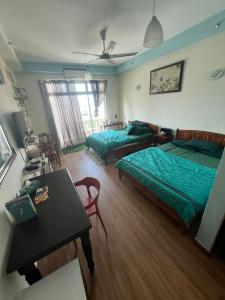 a bedroom with two beds and a table and a table sidx sidx sidx at Studio Apartment KTC KB in Kota Bharu