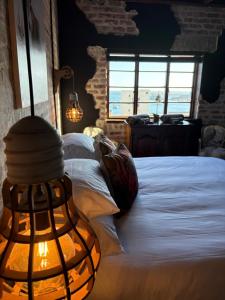 a bedroom with a white bed with a window at Eccentric Heritage Paradise Simon's Town in Simonʼs Town
