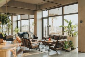 a living room with a couch and chairs and windows at 緩慢大鵬灣 in Donggang