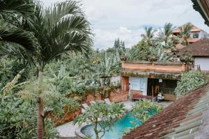 an aerial view of a house with palm trees and a pool at Warsi Bungalow in Ubud