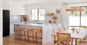 a kitchen with a large island in a kitchen with a table at Amazing 3bd in National Park in Bundeena