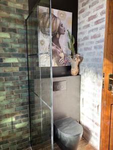 a bathroom with a toilet and a poster on the wall at Eccentric Heritage Paradise Simon's Town in Simonʼs Town +41 photos