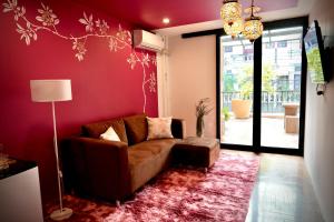 a living room with a couch and a red wall at maross bed and room in Chiang Mai