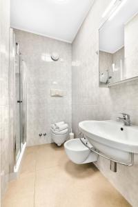 a white bathroom with a sink and a toilet at Jesolo Sun Beach House - Host Solution in Lido di Jesolo +29 photos
