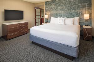 a hotel room with a bed and a flat screen tv at Courtyard Seattle Sea-Tac Area in Tukwila