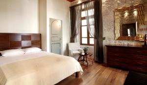 a bedroom with a bed and a chair and a mirror at Leo Hotel in Rethymno