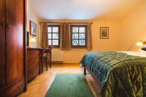 a bedroom with a bed and a desk and a window at Apartments Esplanade in Špindlerův Mlýn