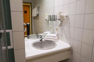 a bathroom with a sink and a mirror at Hotel am Südtor in Backnang +36 photos
