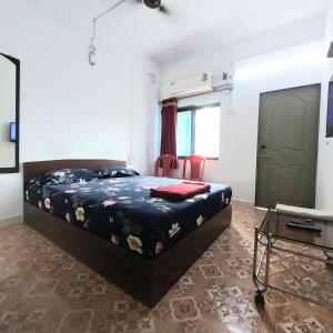a bedroom with a bed and a flat screen tv at Sunita niwas in Malvan